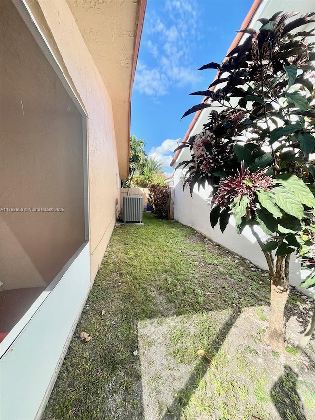 view of yard with fence and central AC