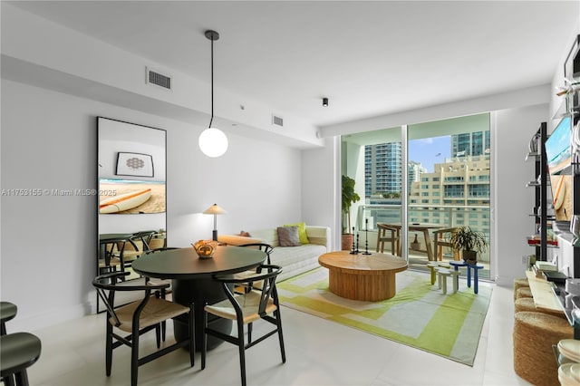 dining space featuring expansive windows, visible vents, and baseboards