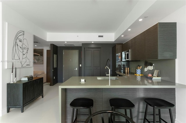 kitchen with a peninsula, a breakfast bar, modern cabinets, and light countertops