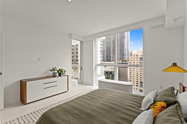 bedroom featuring a city view and floor to ceiling windows