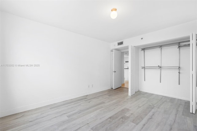 unfurnished bedroom with baseboards, visible vents, and wood finished floors