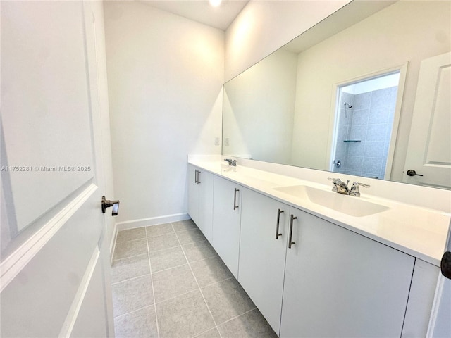 full bathroom featuring tile patterned flooring, a sink, baseboards, tiled shower, and double vanity