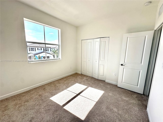 unfurnished bedroom featuring carpet, baseboards, and a closet