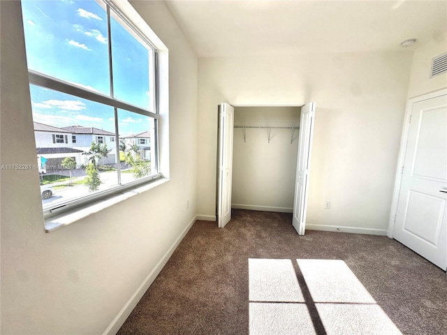 unfurnished bedroom with carpet, baseboards, and a closet