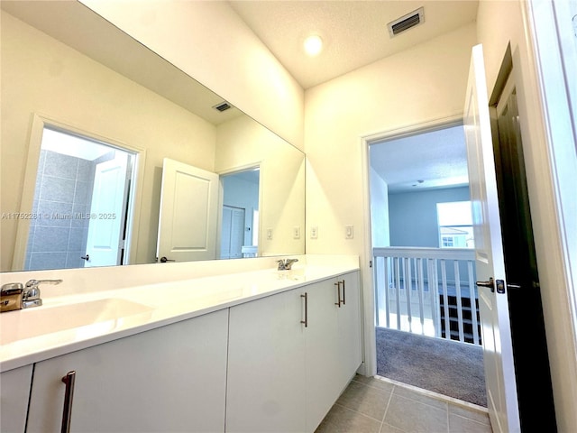 bathroom featuring double vanity, tile patterned flooring, a sink, and visible vents