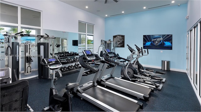 gym featuring a high ceiling, baseboards, and recessed lighting