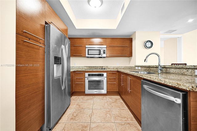 2681 N Flamingo Rd Unit 1103S, Sunrise, FL 33323 - kitchen with appliances with stainless steel finishes, a sink, brown cabinetry, and light stone counters