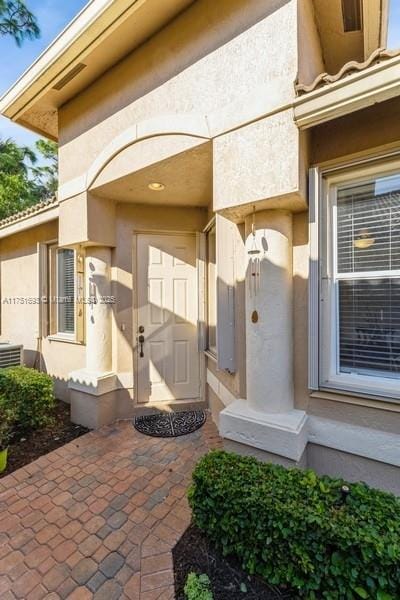 doorway to property featuring stucco siding