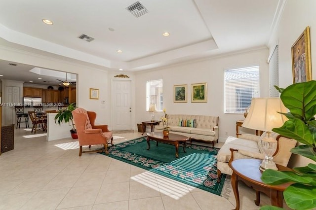 living room featuring visible vents, a tray ceiling, light tile patterned flooring, and a wealth of natural light