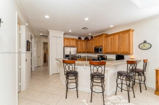 kitchen featuring appliances with stainless steel finishes, visible vents, ornamental molding, and a peninsula