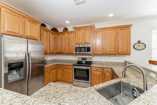 kitchen with stainless steel appliances, visible vents, ornamental molding, a sink, and light stone countertops