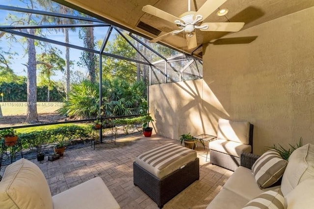 view of patio with glass enclosure, ceiling fan, visible vents, and an outdoor hangout area