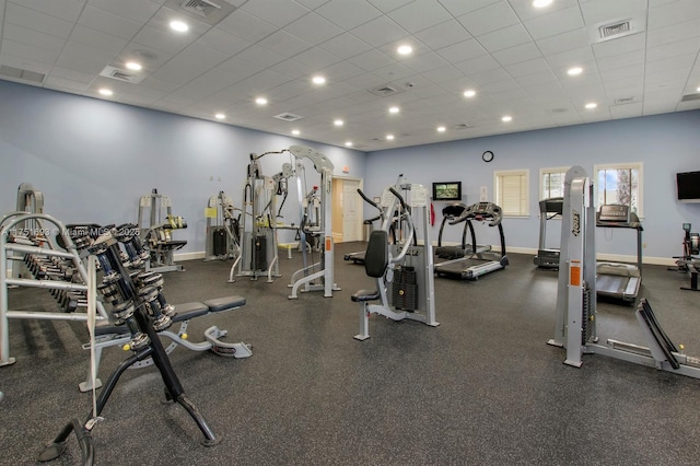 exercise room with a drop ceiling, visible vents, and baseboards