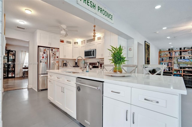 kitchen featuring appliances with stainless steel finishes, visible vents, a sink, and white cabinetry