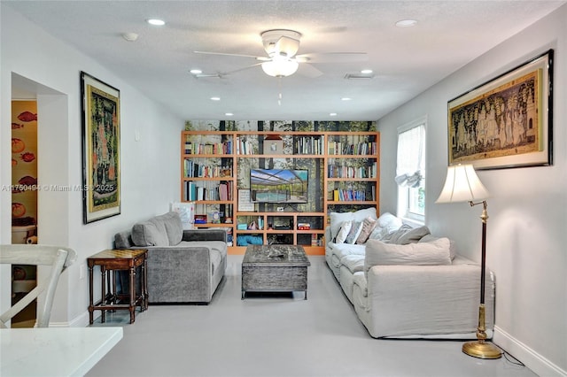 living area featuring recessed lighting, ceiling fan, a textured ceiling, concrete floors, and baseboards