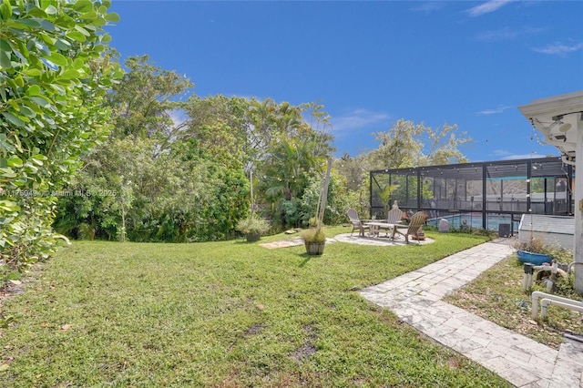 view of yard featuring glass enclosure, a patio area, and an outdoor pool