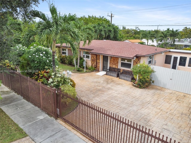 view of front facade with stone siding, a fenced front yard, and a gate