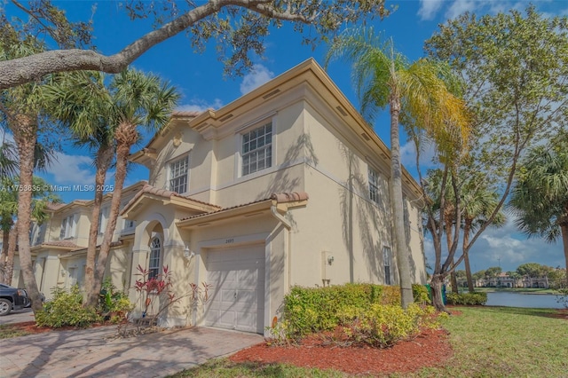 view of front facade with driveway, a garage, and stucco siding