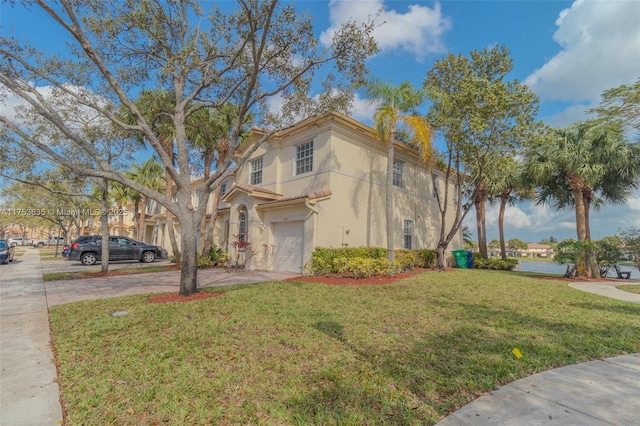 view of front facade featuring driveway, a front lawn, an attached garage, and stucco siding