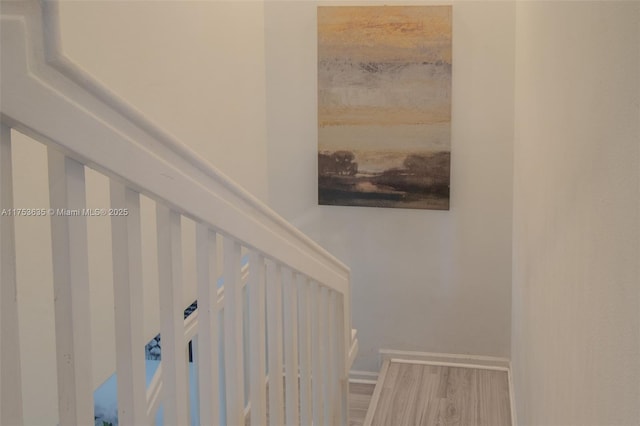 staircase with baseboards and wood finished floors