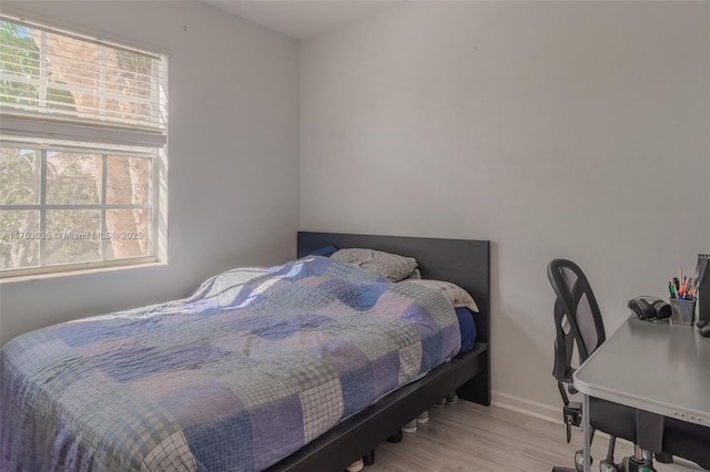 bedroom featuring baseboards and wood finished floors