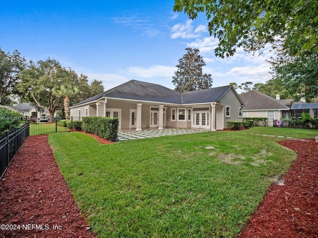 back of house featuring a yard, french doors, a fenced backyard, and stucco siding