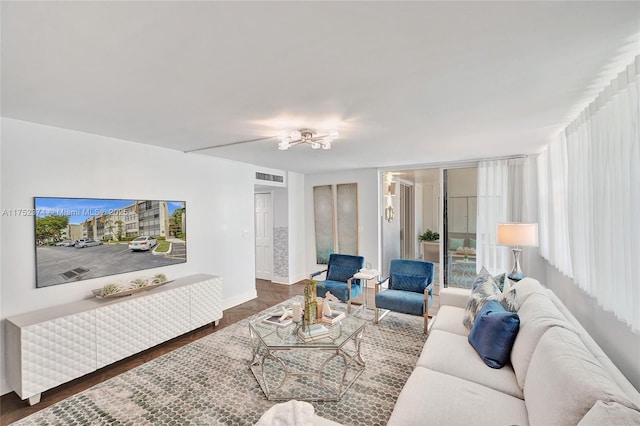 living room with visible vents, baseboards, and wood finished floors