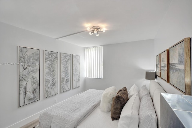 bedroom featuring baseboards and wood finished floors