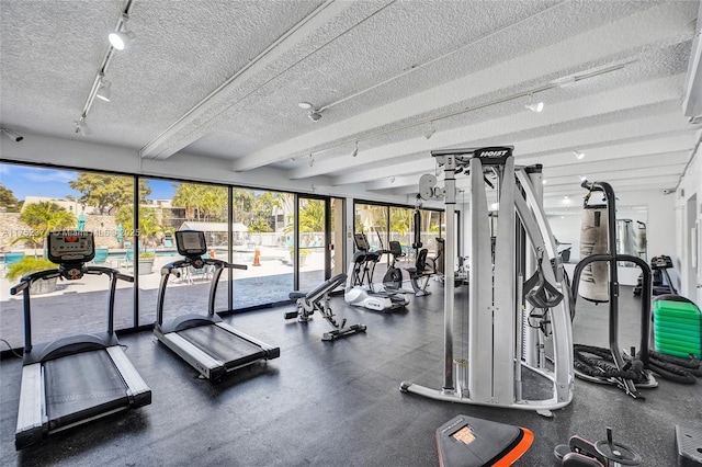 gym with a textured ceiling and rail lighting