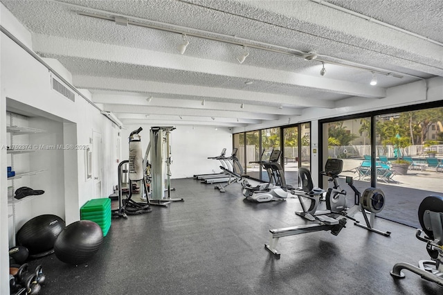 gym featuring a textured ceiling, visible vents, and track lighting