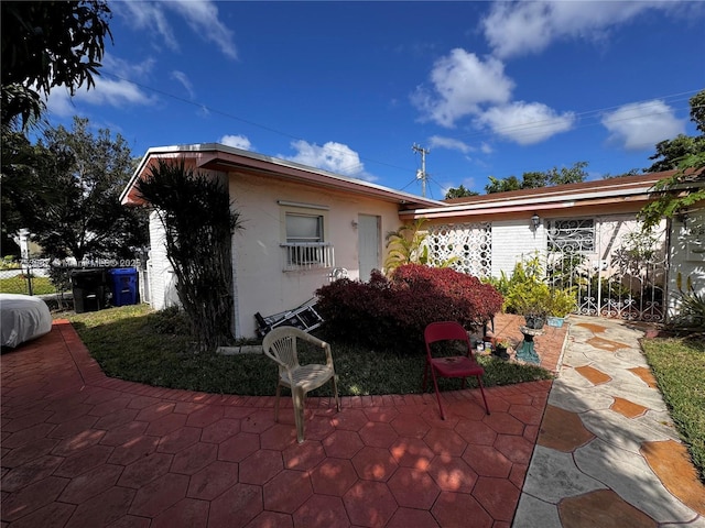 exterior space with stucco siding and a patio area