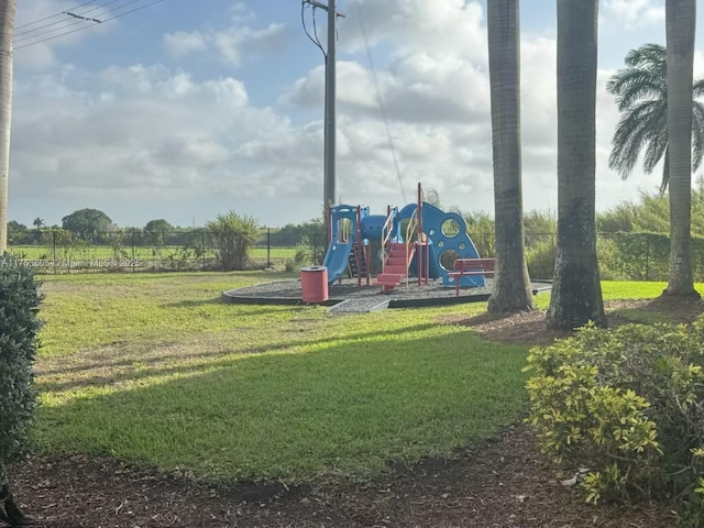 community jungle gym featuring a yard and fence