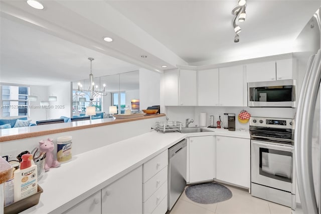 kitchen with white cabinets, stainless steel appliances, light countertops, and open floor plan