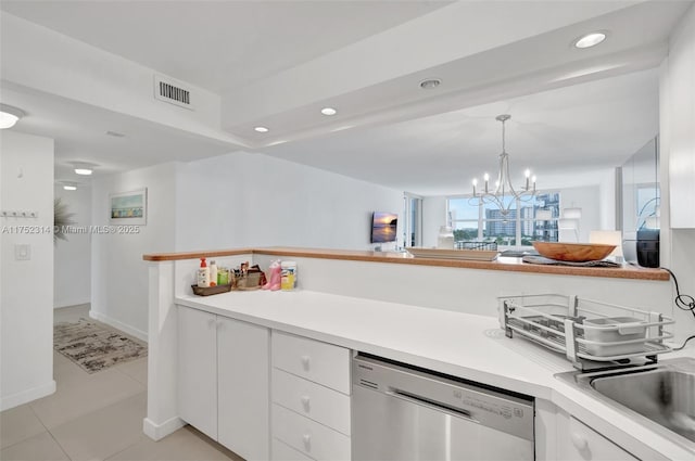 kitchen with visible vents, white cabinets, stainless steel dishwasher, and light countertops