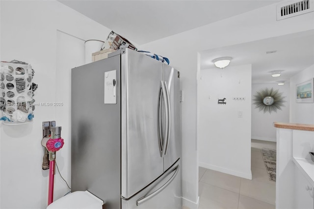 bathroom featuring tile patterned flooring, baseboards, visible vents, and toilet