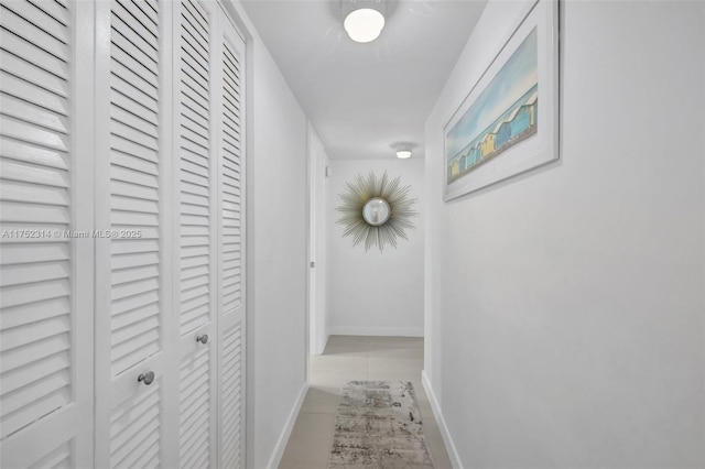 hallway with baseboards and tile patterned floors