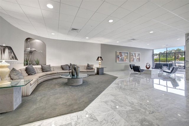 living area featuring arched walkways, marble finish floor, and recessed lighting