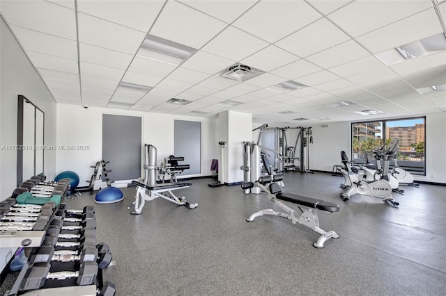 workout area with a drop ceiling, visible vents, and baseboards