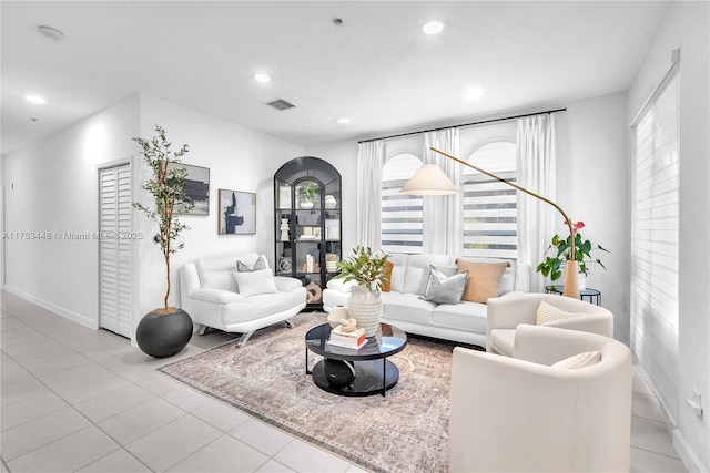 tiled living room with baseboards, visible vents, and recessed lighting