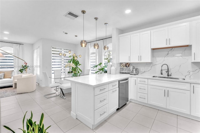 kitchen with visible vents, decorative backsplash, dishwasher, a peninsula, and a sink