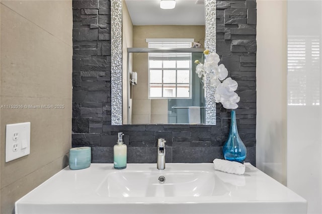 bathroom featuring a sink and backsplash