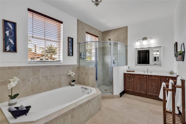 bathroom with a stall shower, a garden tub, and vanity