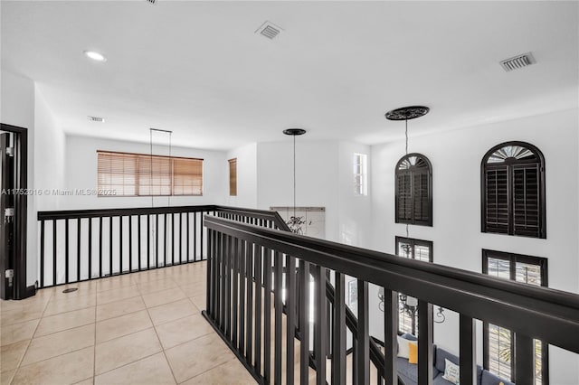 hall featuring light tile patterned floors, recessed lighting, visible vents, and a notable chandelier