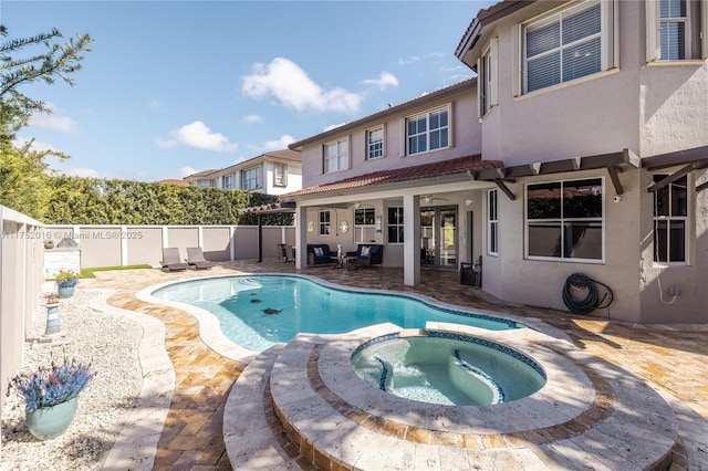 view of pool featuring a fenced backyard, a pool with connected hot tub, and a patio