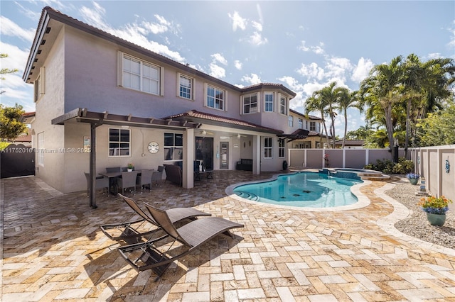 view of pool featuring a patio, a fenced backyard, and a pool with connected hot tub