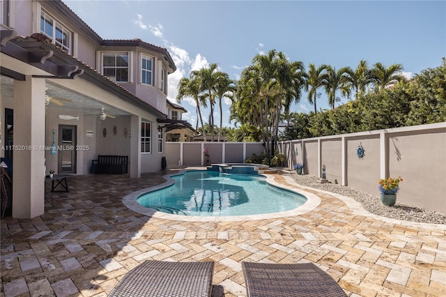 view of swimming pool with a pool with connected hot tub, a fenced backyard, ceiling fan, and a patio