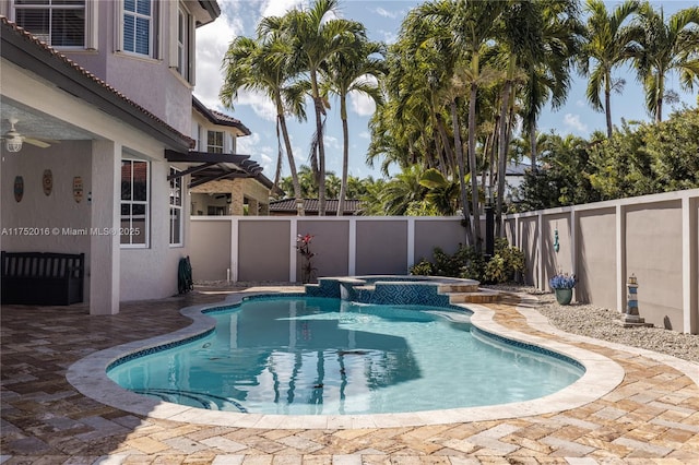 view of swimming pool featuring a patio area, a fenced backyard, and a pool with connected hot tub