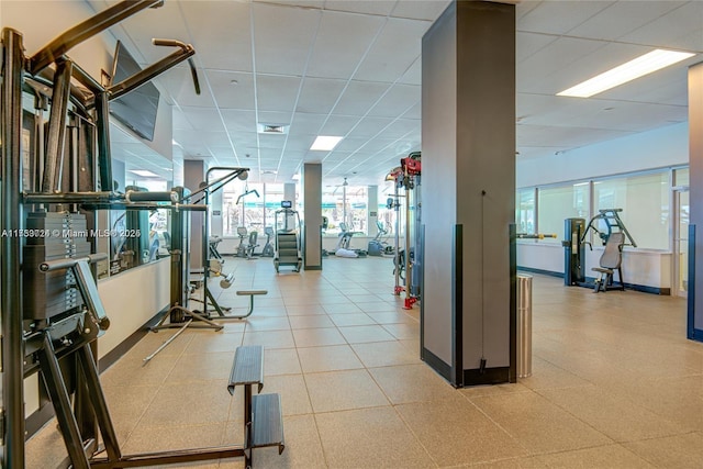 gym with a paneled ceiling, baseboards, and visible vents