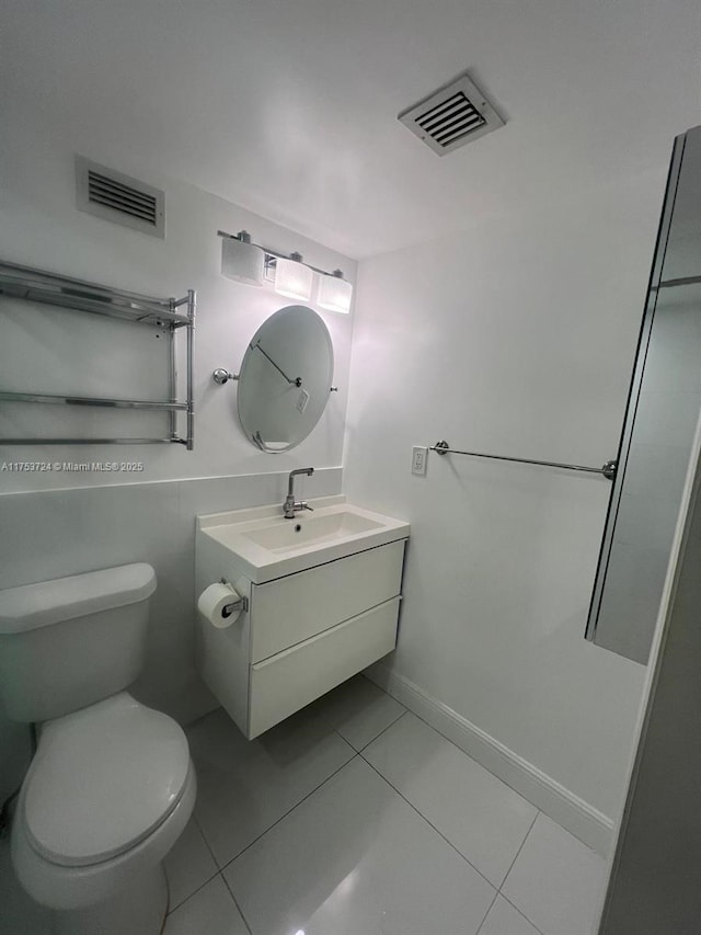 bathroom with visible vents, vanity, toilet, and tile patterned floors