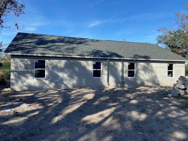 rear view of house featuring roof with shingles